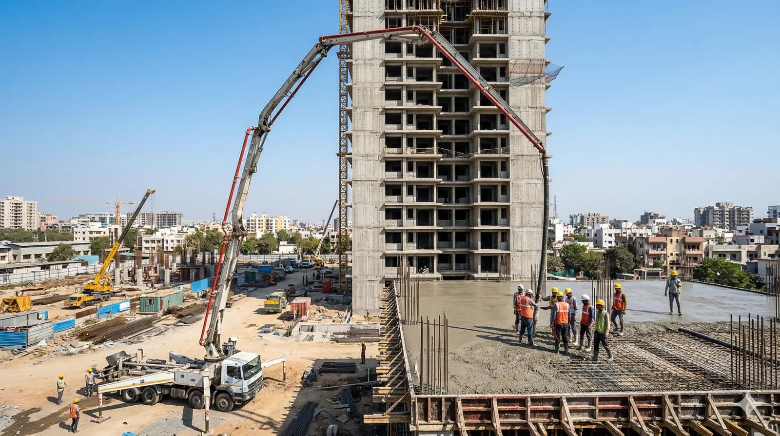 Concrete being pumped via boom arm to an upper floor of a tower under construction